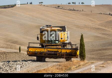 Pienza, Italie - 13 septembre 2011: Moissonneuse-batteuse pendant la récolte et le paysage rural de la Toscane. Italie Banque D'Images