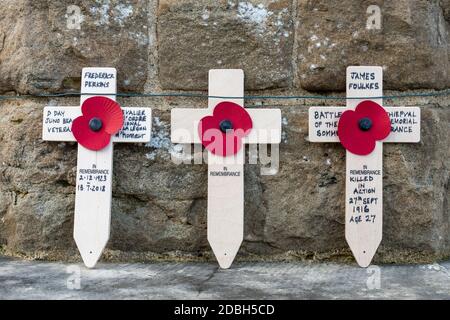 Trois croix de pavot placées autour d'un mémorial de guerre pour commémorer le jour du souvenir ou armistice, Royaume-Uni Banque D'Images