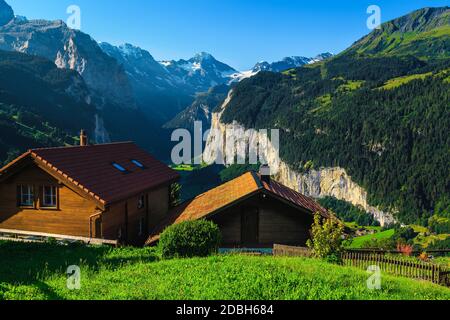 Chalets en bois confortables avec vue imprenable depuis la station de montagne de Wengen. Vallée de Lauterbrunnen et montagnes avec glaciers en arrière-plan, Oberlan bernois Banque D'Images