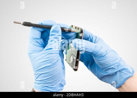 un professionnel répare un disque dur dans des conditions de laboratoire Banque D'Images