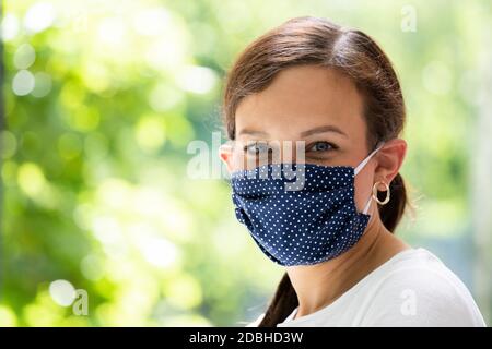 Femme en tissu réutilisable masque facial. Mode quarantaine Covid-19 Banque D'Images