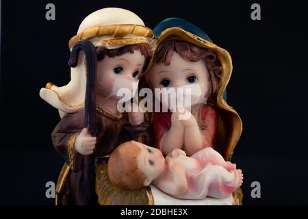 Scène de la nativité de Noël avec des figures délicates dans la nouvelle normale du coronavirus ou covid-19. Jose et Maria avec collier sur fond noir. YE Banque D'Images