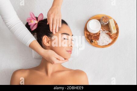 Soins spa. Une femme asiatique détendue, qui se fait maser le visage et s'aromatherapy au salon Banque D'Images