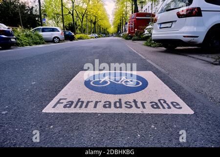 Large piste cyclable dans une avenue avec des voitures garées à Karlsruhe, en Allemagne. L'inscription signifie rue de vélo. Banque D'Images