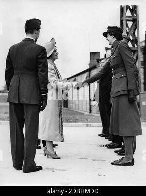 'La reine Elizabeth serre la main avec Mme A.M. Thompson, commandant adjoint du '17th Surrey Womens Auxiliary territorial Service'' à l'exposition de l'étable à ballons. À côté de sa place, le roi George VI.' Banque D'Images