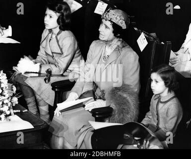 Elizabeth II (à gauche), sa mère la reine Elizabeth (au centre) et sa petite sœur Margaret Rose (à droite) comme auditeurs lors d'un concert de couronnement pour les enfants, qui a eu lieu dans le cadre des célébrations préliminaires à Westminster Central Hall. Banque D'Images