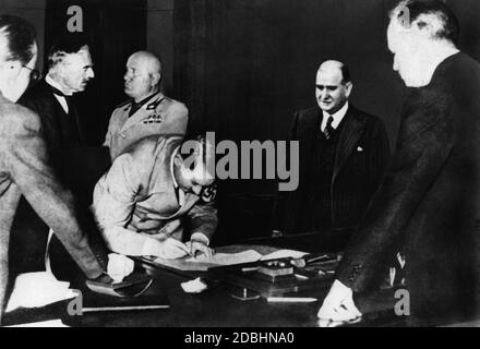 Adolf Hitler signant l'Accord de Munich. En arrière-plan Chamberlain et Benito Mussolini. Sur la droite, Daladier et Ribbentrop. Banque D'Images