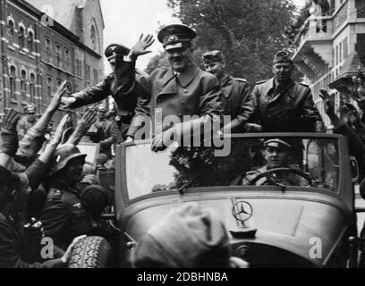 Adolf Hitler est conduit par son chauffeur Erich Kempka dans une ville de l'est de la France. Autour de la Mercedes W31, les membres de la Wehrmacht lui saluent. À droite d'Hitler se trouve son adjudant Julius Schaub. Banque D'Images