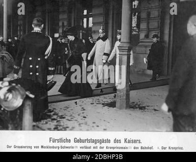 De gauche à droite, la Crown Princess Cecilie de Mecklembourg, un noble et le Crown Prince Wilhelm de Prusse quittent une gare à Berlin. A gauche, un chauffeur ouvre la porte de la voiture pour qu'ils poursuivent leur voyage vers l'empereur Guillaume II, qui a célébré son anniversaire le 27 janvier 1910 et à qui ils ont été invités. Banque D'Images