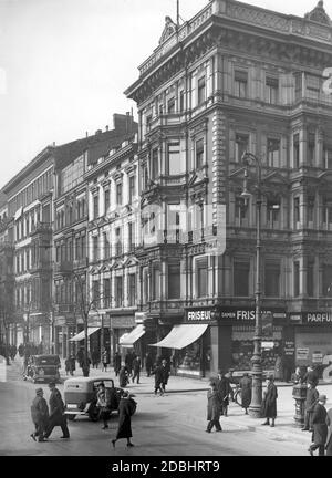 'La photo montre le bloc de maisons à Unter den Linden 59a - 63, angle Neustaedtische Kirchstrasse, à Berlin en 1935 avant sa démolition. Les bâtiments ont dû faire place au chantier de construction du tunnel du S-Bahn Nord-Sud, qui a été conduit plus au nord de la gare d'Unter den Linden (aujourd'hui: Porte de Brandebourg). La photo montre de nombreux magasins dont un coiffeur pour femmes, la maison d'édition ''W. Girardet' et le magasin 'Duerninger Zigarren Herrnhut''. Banque D'Images