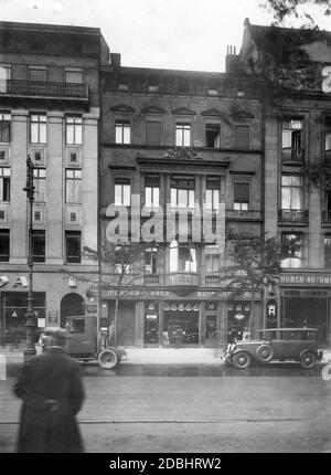 Au centre de la photo se trouve une vieille maison de ville dans la rue Unter den Linden (numéro 42) à Berlin en 1928. Au premier étage, il y a un concessionnaire qui offre, entre autres choses, des Chevrolets américains. Juste à côté est un magasin avec des voitures de tourisme Horch allemand. Banque D'Images