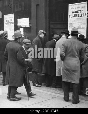 Les passants se tiennent devant des affiches recrutant des travailleurs volontaires pour le chemin de fer comme briseurs de grève lors de la grève générale de Londres. Banque D'Images