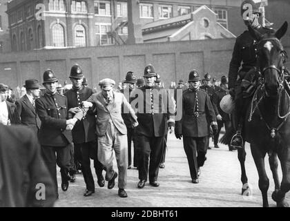 « les policiers emprennent un démonstrateur arrêté dans l'East End de Londres. Auparavant, il y avait eu des affrontements entre communistes et partisans de l'« Union britannique des fascistes » de Sir Oswald Mosley, dans la rue Mint, qui devait être dispersée par la police. » Banque D'Images