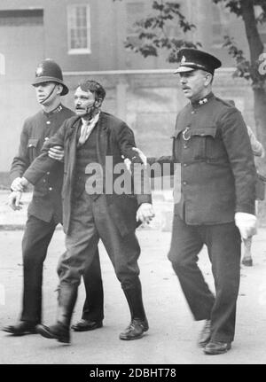 Deux policiers emprennent un manifestant blessé à Londres. Banque D'Images