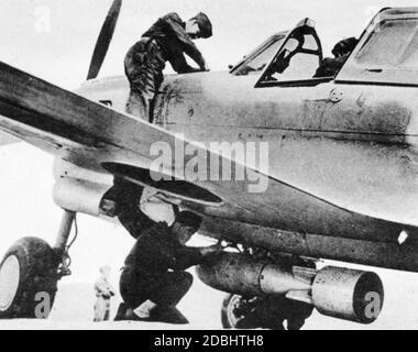 « un soldat monte une bombe sur un Curtiss P-40 ''Kittihawk'' des États-Unis, qui vole des missions en Afrique sous l'emblème anglais. (photo non datée)' Banque D'Images