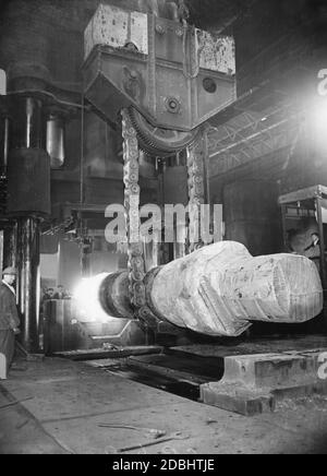 Les travailleurs se tiennent à côté d'une presse industrielle dans une aciérie de Sheffield, en Angleterre. Banque D'Images