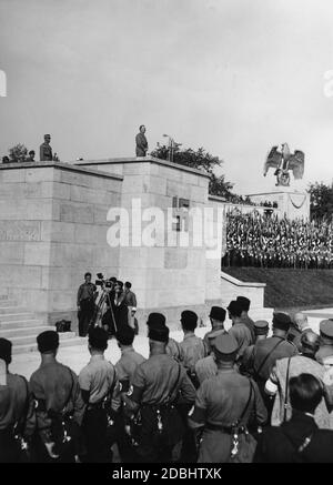 Adolf Hitler prononce un discours à la parade de la sa et de la SS dans la Luitpoldarena lors du Congrès du Parti nazi à Nuremberg. Une équipe de caméras filme sous la tribune, où une croix gammée est exposée. Banque D'Images