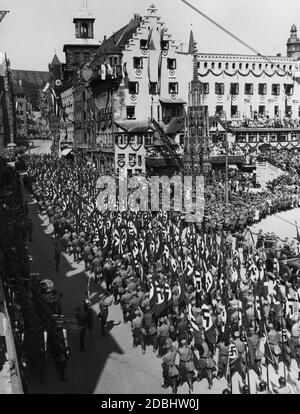 Sur la soi-disant Adolf-Hitler-Platz de Nuremberg, Adolf Hitler (debout à droite dans la voiture) prend le salut de la sa qui passe devant le Congrès du Parti nazi. Banque D'Images