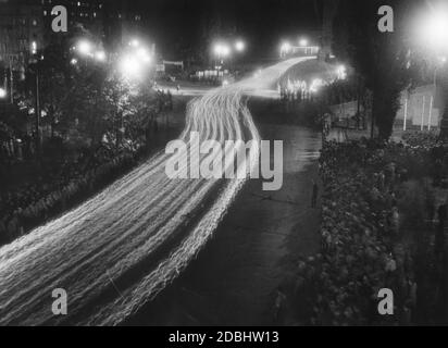 Les dirigeants politiques du NSDAP passent la Bahnhofsplatz à Nuremberg lors de leur procession au flambeaux lors du Congrès du Parti nazi. Il y a des foules de spectateurs des deux côtés de la rue. Banque D'Images