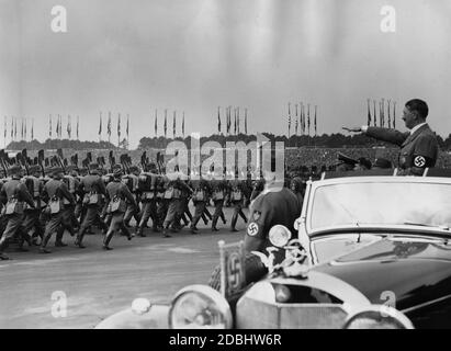 Adolf Hitler, debout dans une Mercedes, inspecte les troupes du Service du travail de Reich sur le champ de Zeppelin au lieu du rassemblement du Parti nazi. En face de lui se trouvent Konstantin Hierl et Wilhelm Frick. Banque D'Images