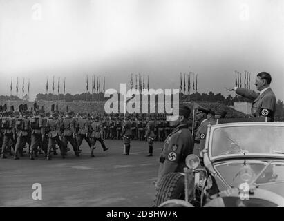 Adolf Hitler, debout dans une Mercedes, inspecte les troupes du Service du travail de Reich sur le champ de Zeppelin au lieu du rassemblement du Parti nazi. En face de lui se trouvent Konstantin Hierl et Wilhelm Frick. Banque D'Images