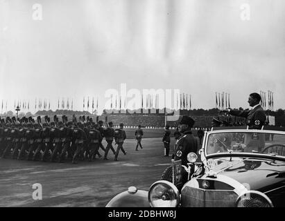 Adolf Hitler, debout dans une Mercedes, inspecte les troupes du Service du travail de Reich sur le champ de Zeppelin au lieu du rassemblement du Parti nazi. En face de lui se trouvent Konstantin Hierl et Wilhelm Frick. Banque D'Images