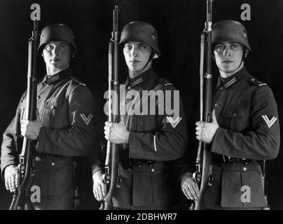 Photo studio des soldats du bataillon de la Garde de Berlin à Praesentiergriff. Ils portent les nouveaux uniformes, Feldblise 36, mais toujours les casques Stahlhelm 18, déjà fournis avec la nouvelle insigne souverain de l'ère nazie. Les fusils sont du type Gewehr 98. Banque D'Images