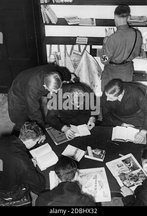 'Étudiants du groupe universitaire de la NSDStB dans la salle de lecture de leur nouvelle maison de camaraderie, la 'Melanchthonhaus' à Sebastianstrasse, Berlin, avec une bibliothèque et un coin journal. Sur la table se trouve une copie de « Mein Kampf » d'Adolf Hitler Banque D'Images