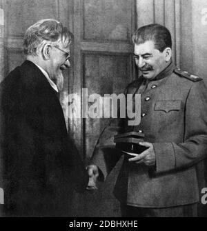 Le chef officiel de l'État de l'Union soviétique, Mikhail Ivanovich Kalinin, avec le dictateur Joseph V. Staline. Kalinin remet à Staline une médaille de victoire pour l'excellente organisation de la suppression de l'armée allemande. Banque D'Images