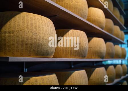 PARME ITALIE - SEPTEMBRE, 2019: Rangées de roues de fromage Parmigiano Reggiano sur des étagères en bois prêtes à la vente Banque D'Images