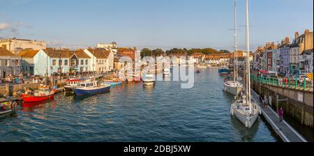 Vue sur les bateaux dans le vieux port et les maisons de quai au coucher du soleil, Weymouth, Dorset, Angleterre, Royaume-Uni, Europe Banque D'Images