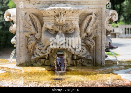 Fontaine en marbre en forme de tête d'homme dans les jardins de la Villa Borghèse, Rome, Italie. Banque D'Images