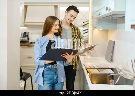 Couple de famille choisissant des garnitures de cuisine dans la salle d'exposition de magasin de meubles. Homme et femme à la recherche d'assortiment dans la boutique, mari et femme achète des biens pour moderne Banque D'Images