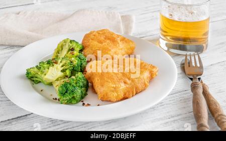 Poisson grillé avec brocoli vapeur et verre de bière Banque D'Images