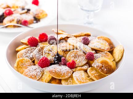 Poffertjes - petites crêpes hollandaises aux framboises fraîches. Cuisine hollandaise traditionnelle. Banque D'Images