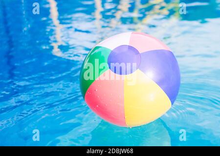 Le ballon de plage coloré est sur l'eau dans la piscine en été. Banque D'Images