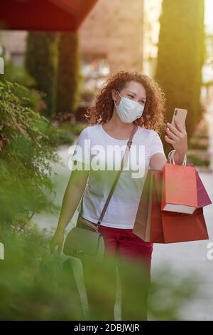Jeune femme en masque sur une frénésie de shopping Banque D'Images