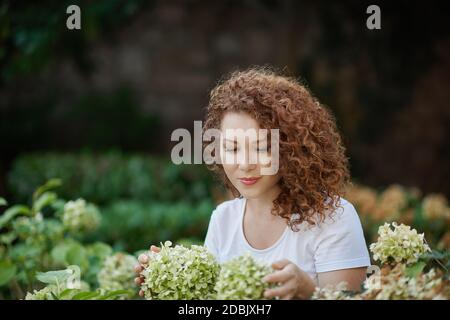 Jeune femme qui s'occupe de la verdure sur sa terrasse Banque D'Images