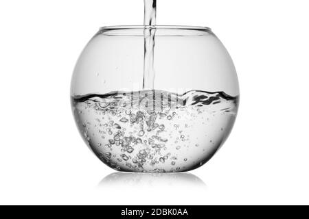 Jet d'eau de farines dans un bol en verre avec bulles isolées sur un fond blanc sans reflet. Réflexion sur la surface. Rétroéclairage. Banque D'Images