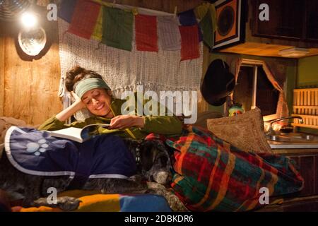 Jeune femme et chien de sieste à l'intérieur de la maison automobile, Gila Wilderness, Nouveau-Mexique, États-Unis Banque D'Images