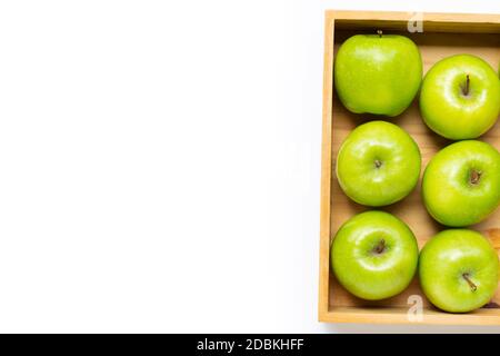 Pommes vertes mûres dans une boîte en bois sur fond blanc. Copier l'espace Banque D'Images