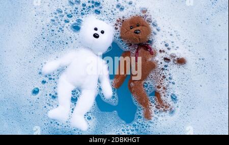 Faire tremper l'ours en peluche dans le détergent à lessive eau dissolution avant de laver. Concept de blanchisserie, vue du dessus Banque D'Images