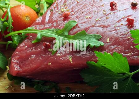 Tranche de viande crue avec arugula et épices Banque D'Images