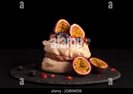 Pavlova dessert mélanger des fruits sur fond sombre. Gâteau culinaire manger. Banque D'Images