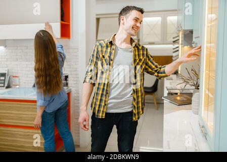 Couple familial achetant des meubles de cuisine dans la salle d'exposition de magasin de meubles. Homme et femme à la recherche d'assortiment dans la boutique, mari et femme achète des biens pour moderne h Banque D'Images