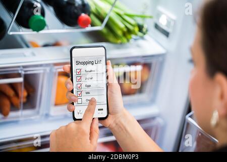 Application pratique pour le téléphone de la liste de courses d'épicerie près du réfrigérateur Banque D'Images