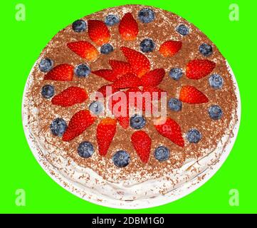 Gâteau rond sur fond vert avec fraises et bleuets. Banque D'Images