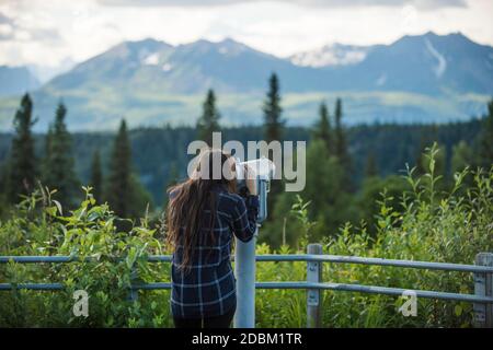 Femme randonneur usingÃ‚' coin-operatedÃ‚' jumelles, Alaska, Etats-Unis Banque D'Images