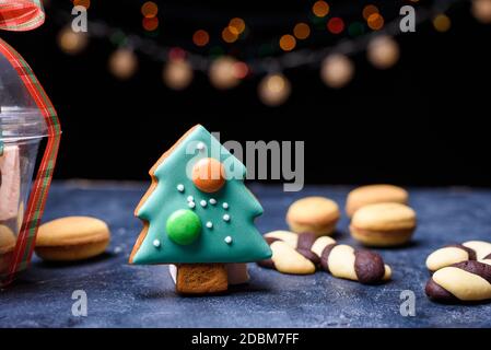 Pain d'épice sous la forme d'un petit arbre de Noël vert, biscuits sablés sous la forme de bonbons. Les lumières et le contenu du nouvel an. Joyeux noël Banque D'Images