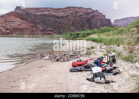 Femme se reposant dans un sac de couchage près du fleuve Colorado, Grand Canyon, Arizona, États-Unis Banque D'Images